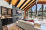 Experience luxury mountain living in this stunning great room, featuring a modern gas fireplace set against a dramatic stacked stone accent wall.