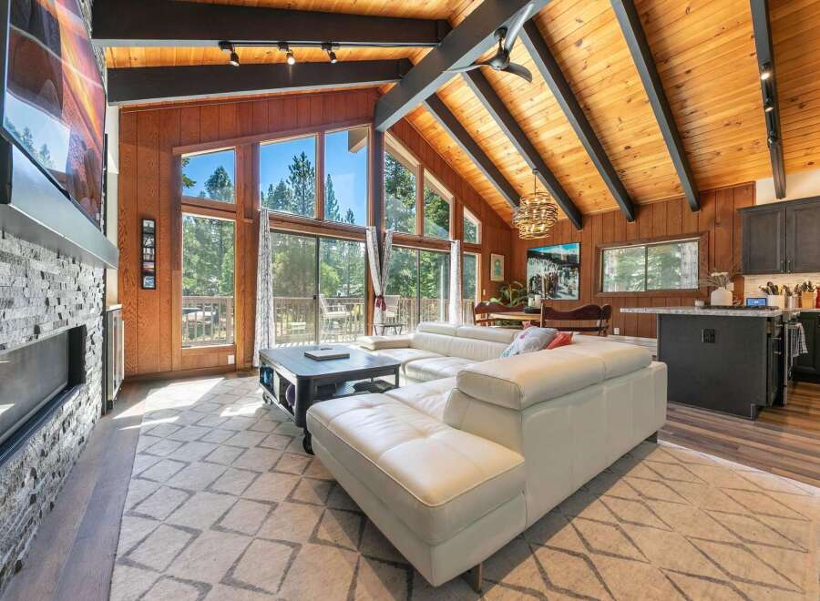 Experience breathtaking mountain living in this stunning home featuring a spacious open-concept living area with a soaring vaulted ceiling and exposed wood beams.