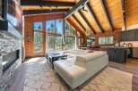 Experience breathtaking mountain living in this stunning home featuring a spacious open-concept living area with a soaring vaulted ceiling and exposed wood beams.