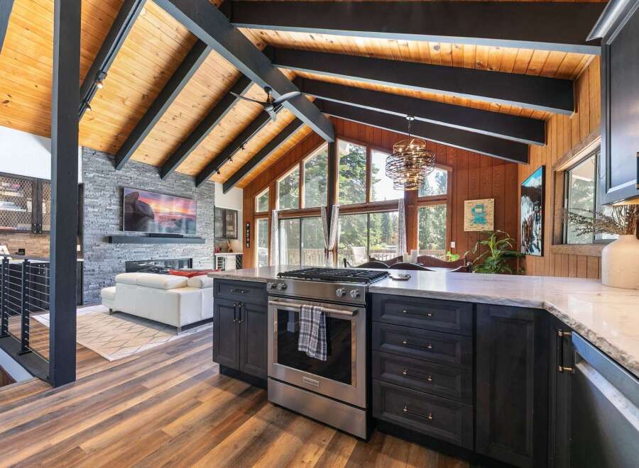 Experience luxury living in this stunning home featuring a vaulted wood-beamed ceiling and a modern open-concept living space.
