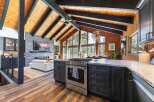 Experience luxury living in this stunning home featuring a vaulted wood-beamed ceiling and a modern open-concept living space.