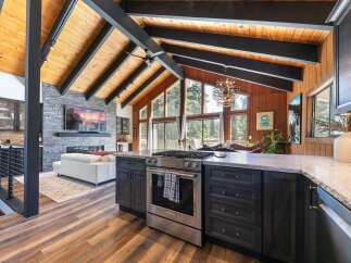 Experience luxury living in this stunning home featuring a vaulted wood-beamed ceiling and a modern open-concept living space.