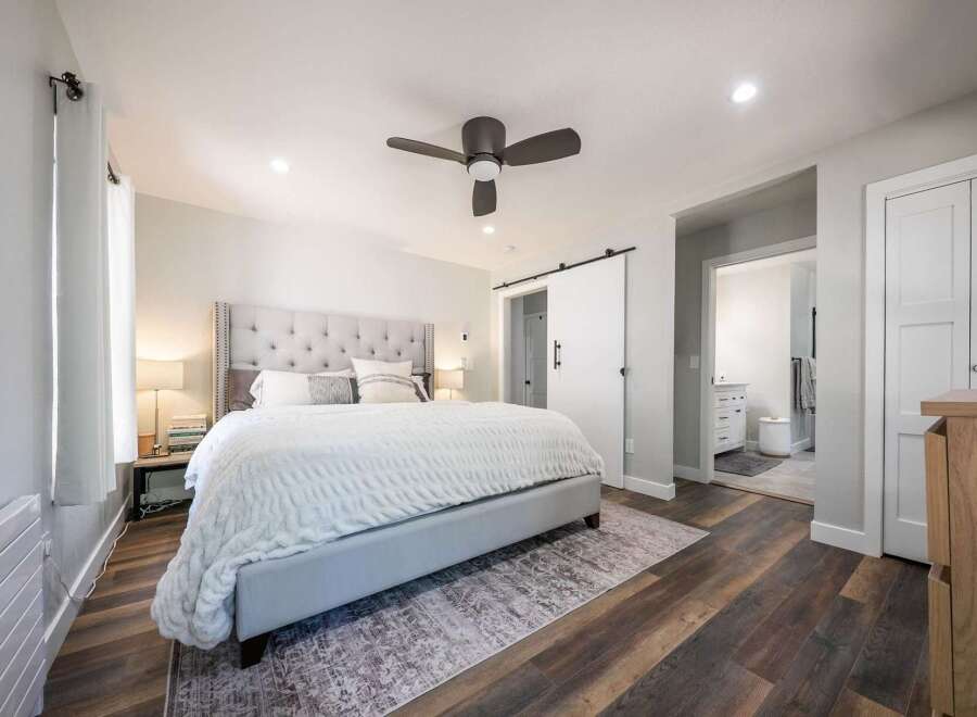 Experience luxury and comfort in this master bedroom, featuring a plush tufted headboard and a cozy white duvet.