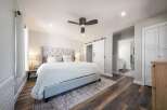 Experience luxury and comfort in this master bedroom, featuring a plush tufted headboard and a cozy white duvet.