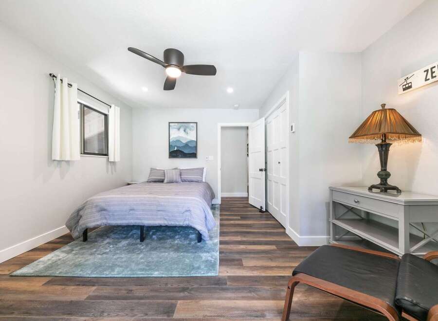 This charming bedroom features a comfortable queen-size bed adorned with a striped duvet and plush pillows, creating a cozy retreat.