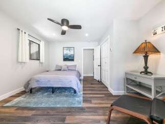 This charming bedroom features a comfortable queen-size bed adorned with a striped duvet and plush pillows, creating a cozy retreat.