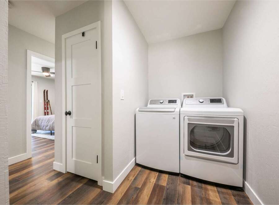 Discover the convenience of this modern laundry room, featuring a stacked washer and dryer set.