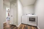 Discover the convenience of this modern laundry room, featuring a stacked washer and dryer set.