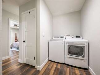 Discover the convenience of this modern laundry room, featuring a stacked washer and dryer set.