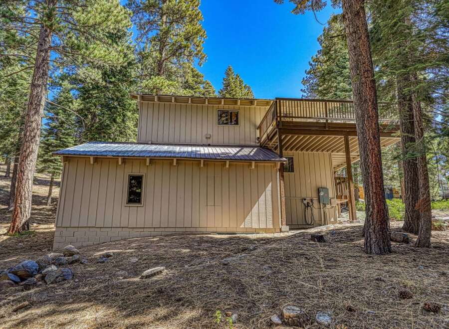 Nestled among tall pine trees, this charming home offers a serene mountain retreat.