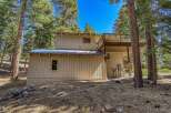 Nestled among tall pine trees, this charming home offers a serene mountain retreat.