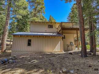 Nestled among tall pine trees, this charming home offers a serene mountain retreat.