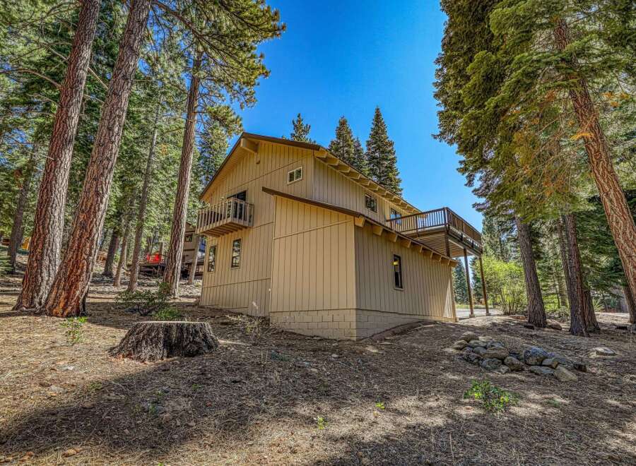 Nestled amongst tall pine trees, this charming home offers a serene mountain retreat.