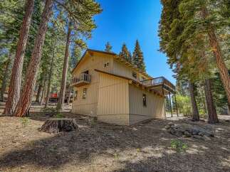 Nestled amongst tall pine trees, this charming home offers a serene mountain retreat.