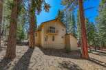 Nestled among tall pine trees, this charming home offers a serene mountain retreat.