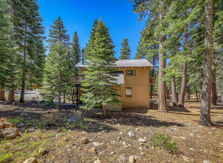 Nestled amidst towering pine trees, this charming home offers a serene mountain retreat.