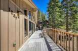 Enjoy the serene mountain lifestyle from this spacious deck, perfect for outdoor entertaining or quiet relaxation amidst towering pine trees.
