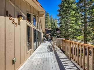 Enjoy the serene mountain lifestyle from this spacious deck, perfect for outdoor entertaining or quiet relaxation amidst towering pine trees.
