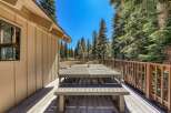 Enjoy al fresco dining on this spacious wooden deck, complete with a large picnic table and benches, perfect for gathering with loved ones.