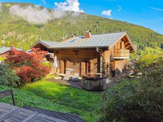 Experience alpine luxury in this charming wooden chalet, featuring a private hot tub perfect for relaxing after a day of adventure.