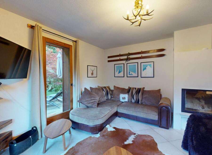 Experience cozy living in this charming mountain retreat, featuring a plush sectional sofa perfect for relaxing evenings.