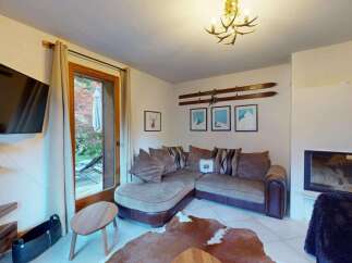 Experience cozy living in this charming mountain retreat, featuring a plush sectional sofa perfect for relaxing evenings.