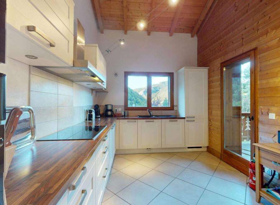 Experience the charm of this mountain retreat kitchen, featuring sleek white cabinetry and warm wooden countertops.