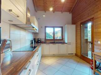 Experience the charm of this mountain retreat kitchen, featuring sleek white cabinetry and warm wooden countertops.
