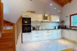 Discover this charming kitchen featuring a sleek stainless steel range hood and modern built-in ovens.
