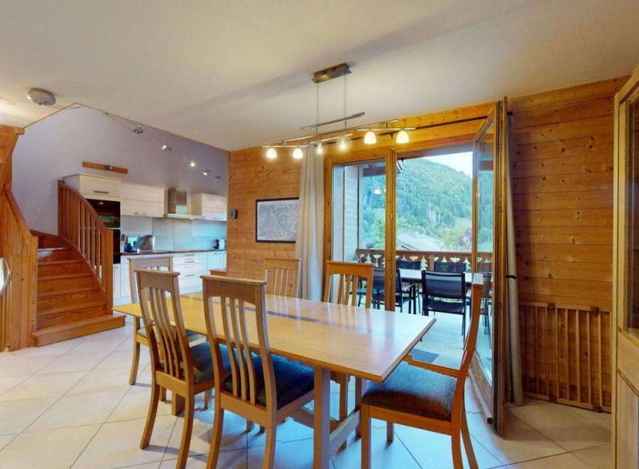 Experience mountain living in this charming dining area featuring a warm wooden interior and a spacious dining table perfect for family gatherings.