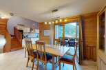 Experience mountain living in this charming dining area featuring a warm wooden interior and a spacious dining table perfect for family gatherings.
