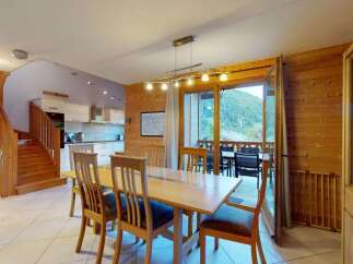 Experience mountain living in this charming dining area featuring a warm wooden interior and a spacious dining table perfect for family gatherings.