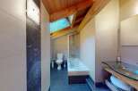 Discover this charming bathroom featuring a sleek glass vanity and a modern bathtub with a shower.