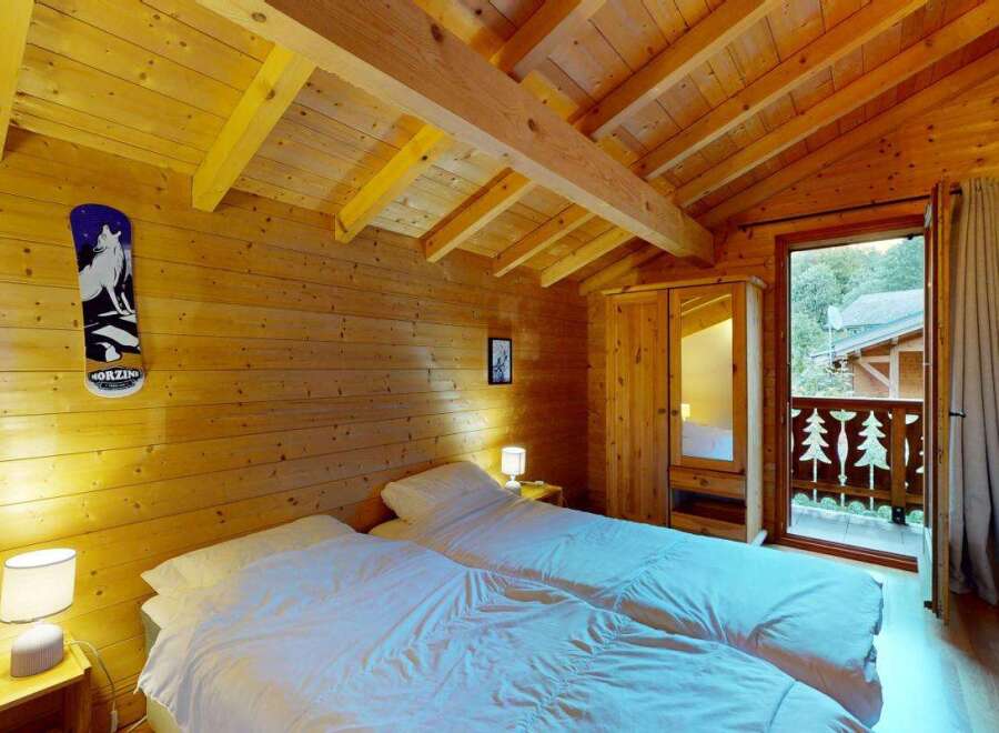Experience cozy mountain living in this charming wooden cabin bedroom, featuring two comfortable twin beds perfect for a restful night's sleep.