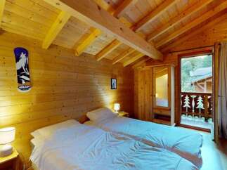 Experience cozy mountain living in this charming wooden cabin bedroom, featuring two comfortable twin beds perfect for a restful night's sleep.