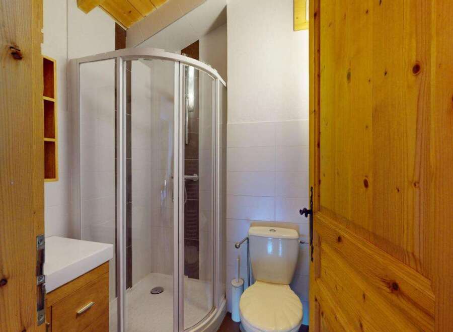 Discover this charming bathroom featuring a modern shower enclosure and a clean white vanity with ample storage.