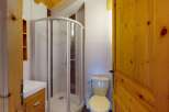 Discover this charming bathroom featuring a modern shower enclosure and a clean white vanity with ample storage.