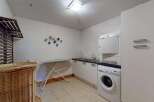This laundry room offers ample space and functionality, featuring a stacked washer and dryer for efficient use of space.