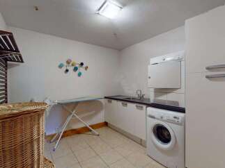 This laundry room offers ample space and functionality, featuring a stacked washer and dryer for efficient use of space.