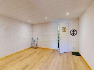 Step into this charming room, featuring a rustic wooden door and walls clad in light-toned wood paneling.