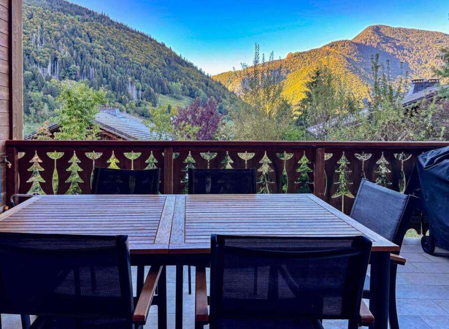 Enjoy breathtaking mountain views from this charming outdoor dining area, perfect for al fresco meals.