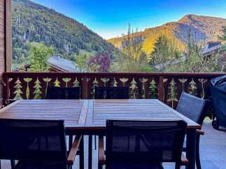 Enjoy breathtaking mountain views from this charming outdoor dining area, perfect for al fresco meals.