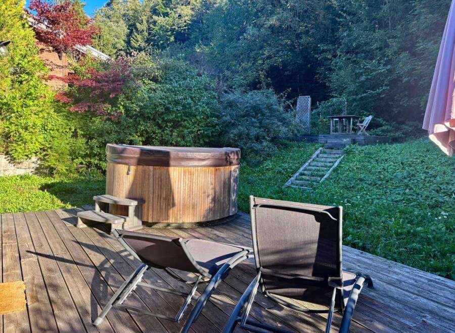 Relax and unwind in this serene backyard oasis, featuring a luxurious wooden hot tub perfect for soaking under the stars.