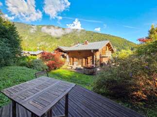 Experience serene mountain living in this charming wooden chalet, complete with a private hot tub perfect for relaxation.