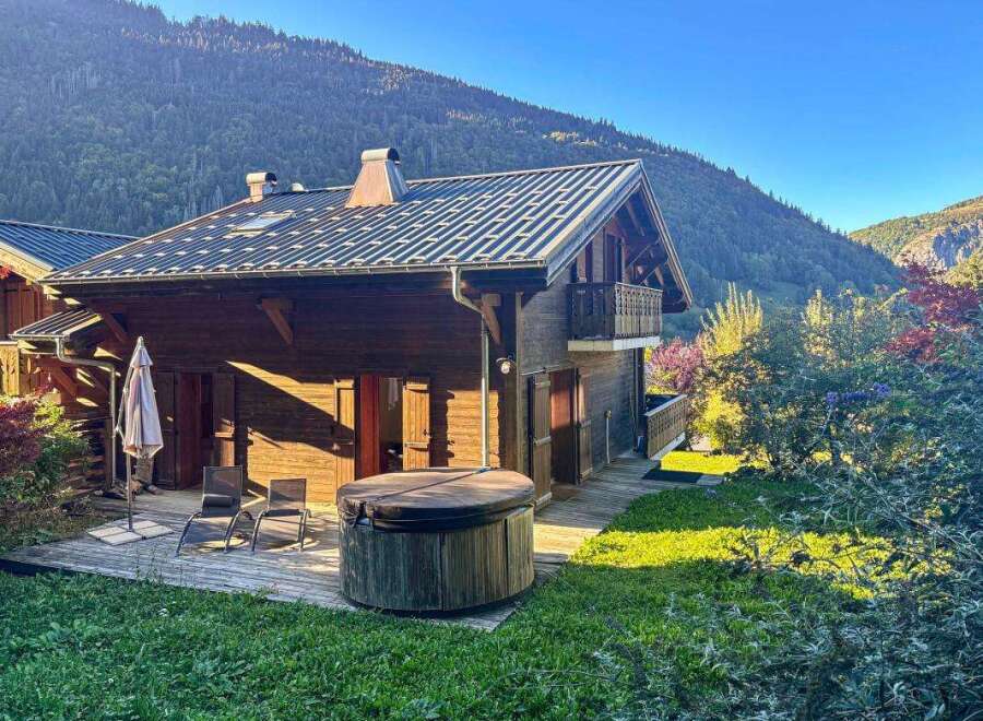 Experience serene mountain living in this charming wooden chalet, complete with a relaxing hot tub on the deck.