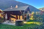 Experience serene mountain living in this charming wooden chalet, complete with a relaxing hot tub on the deck.