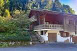 Nestled amidst lush greenery and towering trees, this charming wooden chalet offers a serene mountain retreat.