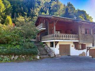 Nestled amidst lush greenery and towering trees, this charming wooden chalet offers a serene mountain retreat.