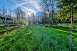 Experience serene living in this picturesque property, featuring a charming wooden fence and lush green meadows perfect for outdoor activities.