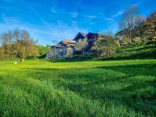 Discover this charming property nestled on a lush green hillside, offering breathtaking views and a serene atmosphere.